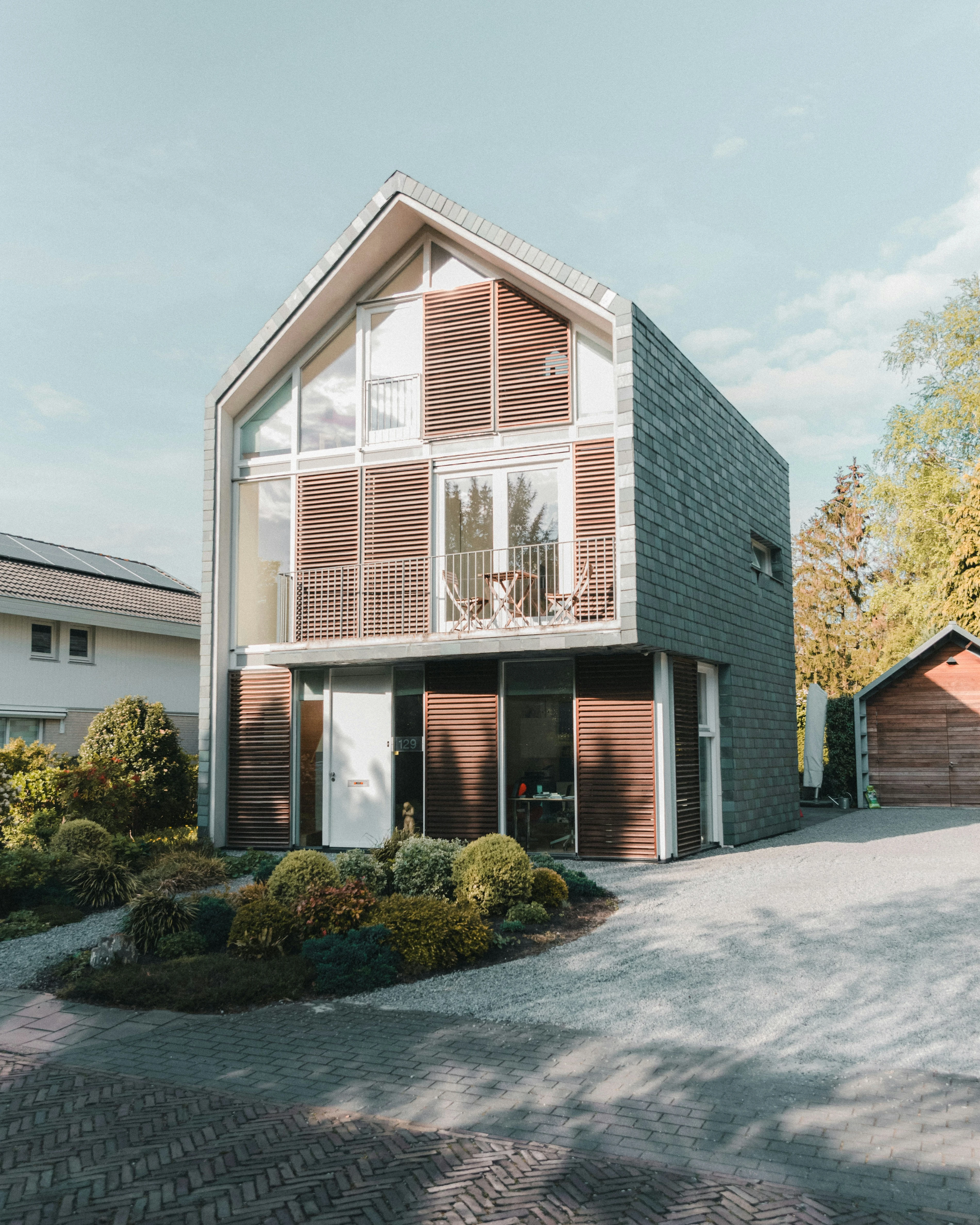 Modernes Gebäude im Bau mit Kränen vor blauem Himmel
